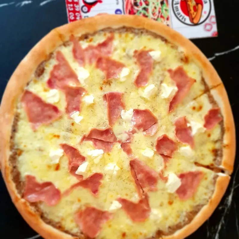 Pizza with ham and soft white cheese, seen from above