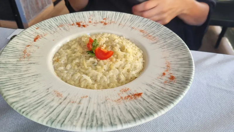 Creamy risotto with a cherry tomato in a wide plate