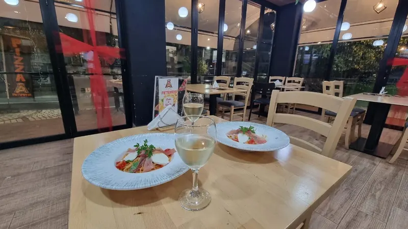 A table laid with two plates and white wine in the bright dining room