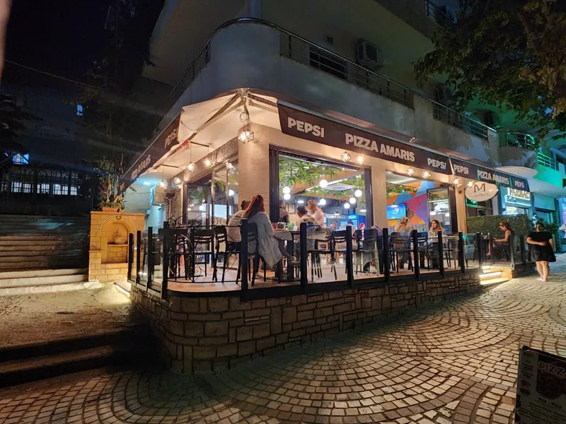 The Pizza AMARIS corner terrace lit up at night